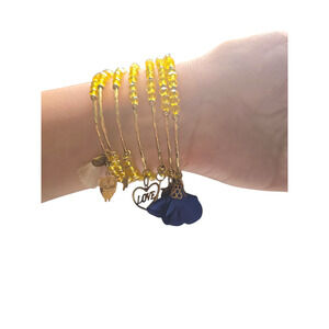 Rubylishious 
Handmade yellow glass bead memory wire bracelet 
With gold, white